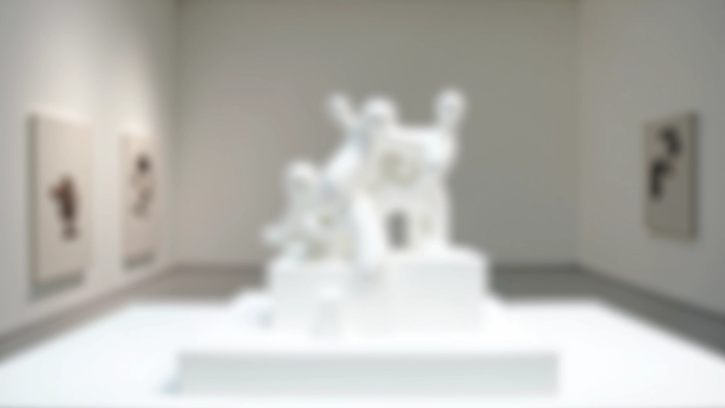 Detailed scale model of a sculpture installation displayed on a white platform with architectural reference materials